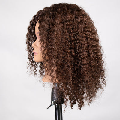 A mannequin head with tight curl hair, featuring a brown tone and positioned on a stand.